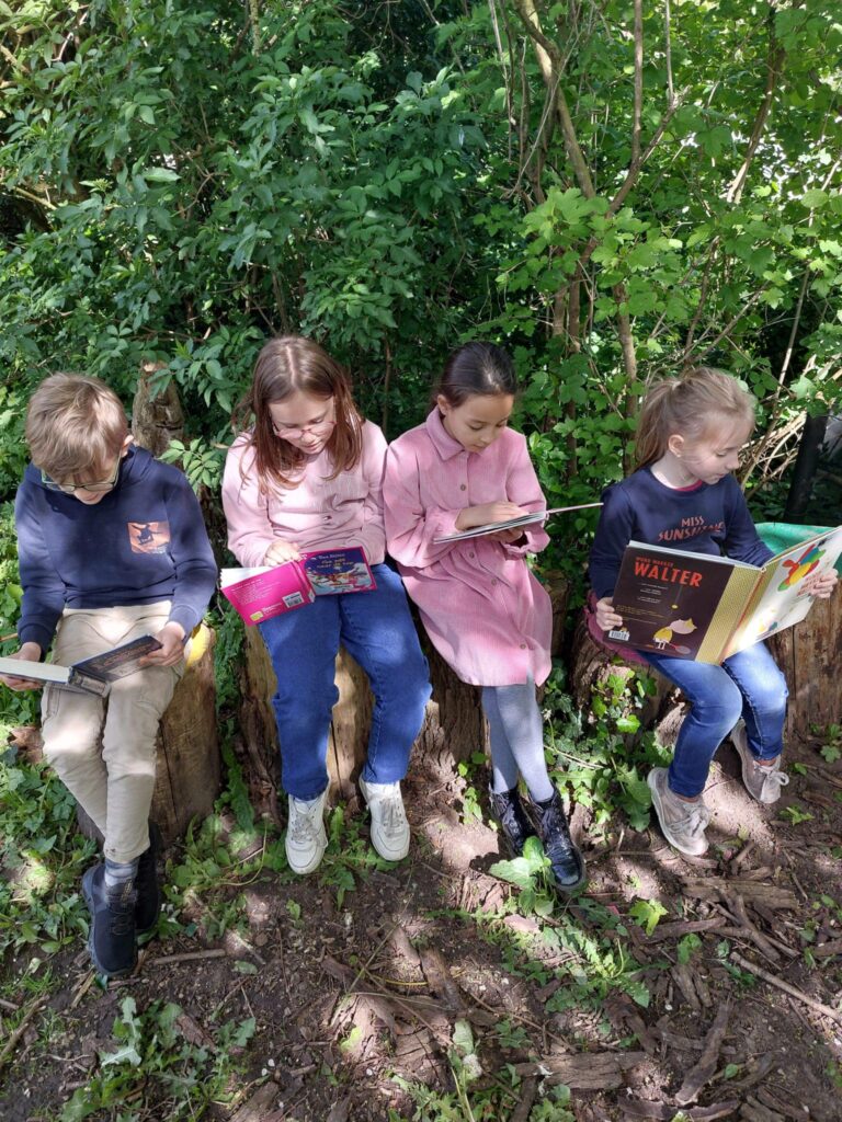 Leerlingen lezen op boomstammetjes